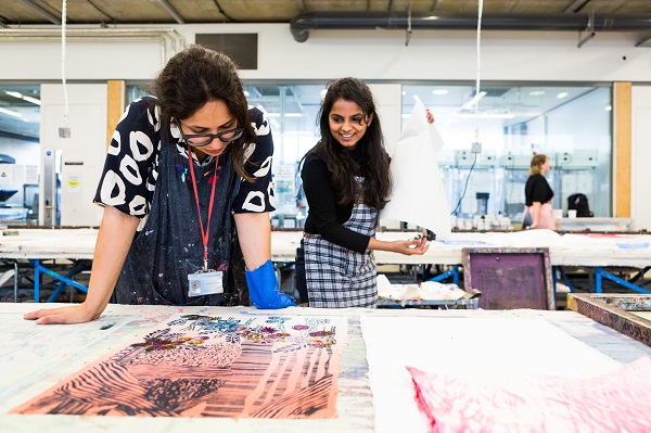 Two women looking at the textile design